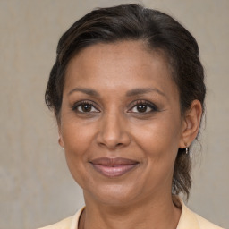 Joyful black adult female with medium  brown hair and brown eyes