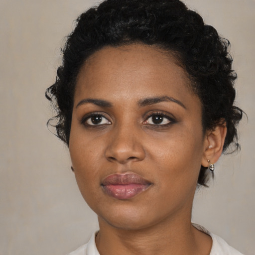 Joyful black young-adult female with short  black hair and brown eyes