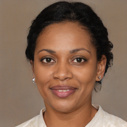 Joyful black adult female with short  black hair and brown eyes