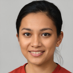 Joyful latino young-adult female with medium  brown hair and brown eyes