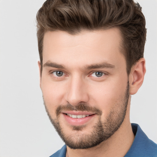 Joyful white young-adult male with short  brown hair and grey eyes