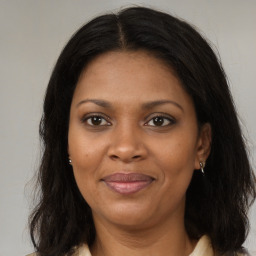 Joyful black adult female with long  brown hair and brown eyes