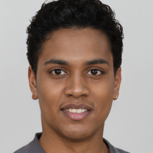 Joyful black young-adult male with short  black hair and brown eyes