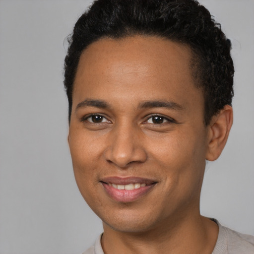 Joyful black young-adult male with short  brown hair and brown eyes