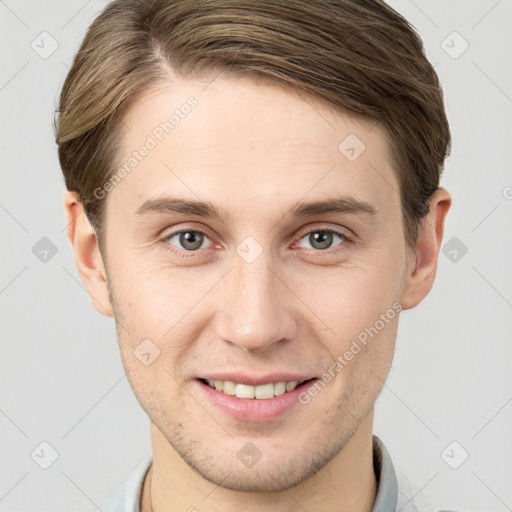 Joyful white young-adult male with short  brown hair and grey eyes