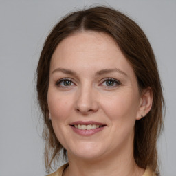 Joyful white young-adult female with medium  brown hair and grey eyes