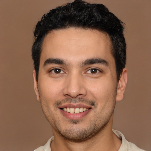 Joyful latino young-adult male with short  brown hair and brown eyes