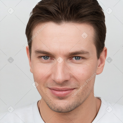 Joyful white young-adult male with short  brown hair and grey eyes