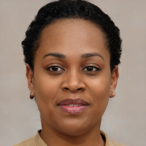 Joyful black young-adult female with short  brown hair and brown eyes