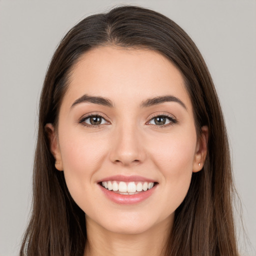 Joyful white young-adult female with long  brown hair and brown eyes