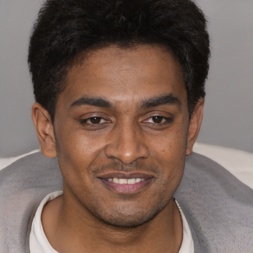 Joyful latino young-adult male with short  brown hair and brown eyes