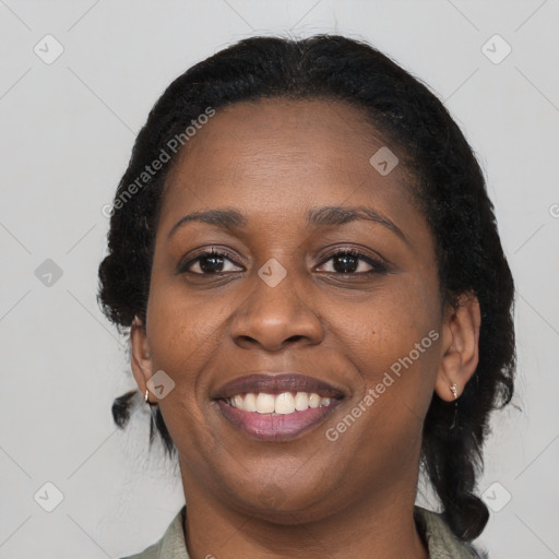 Joyful black young-adult female with long  brown hair and brown eyes