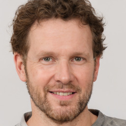 Joyful white adult male with short  brown hair and grey eyes