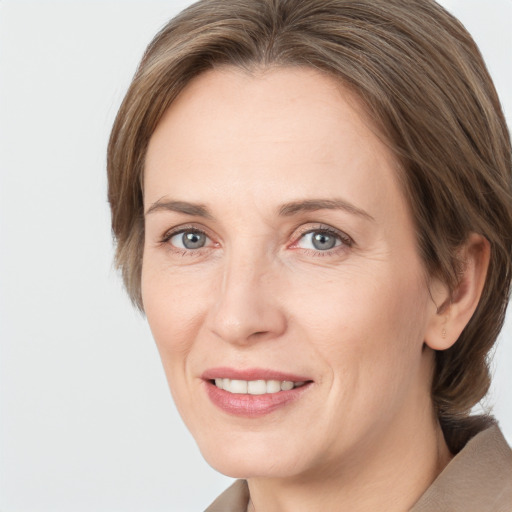 Joyful white adult female with medium  brown hair and grey eyes