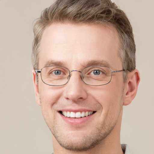 Joyful white adult male with short  brown hair and grey eyes