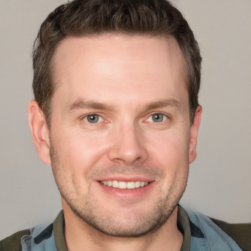 Joyful white adult male with short  brown hair and grey eyes