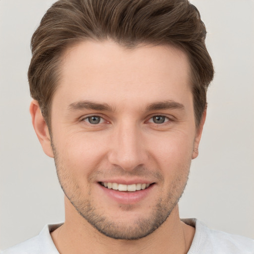 Joyful white young-adult male with short  brown hair and grey eyes