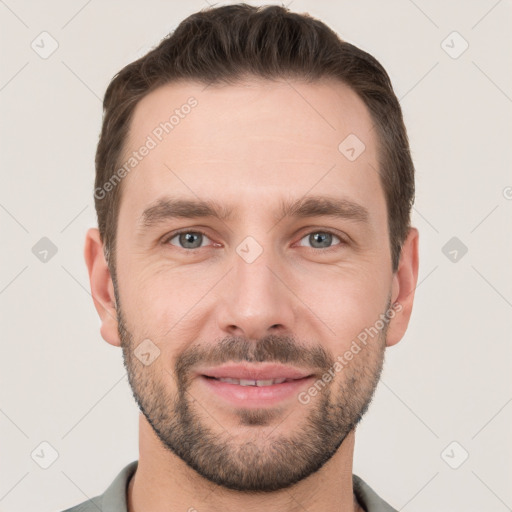 Joyful white young-adult male with short  brown hair and grey eyes