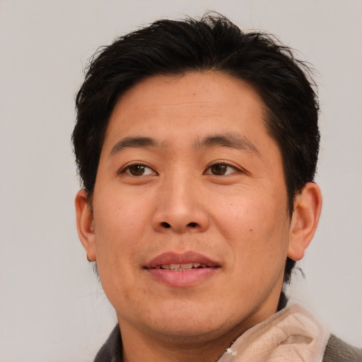 Joyful asian adult male with short  brown hair and brown eyes