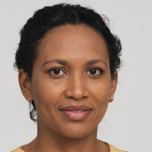 Joyful black adult female with short  brown hair and brown eyes