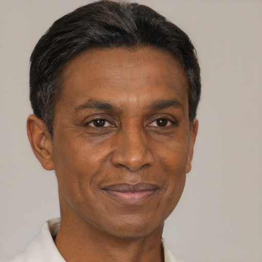 Joyful black adult male with short  brown hair and brown eyes