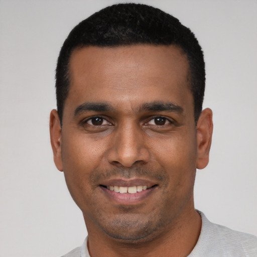 Joyful latino young-adult male with short  black hair and brown eyes