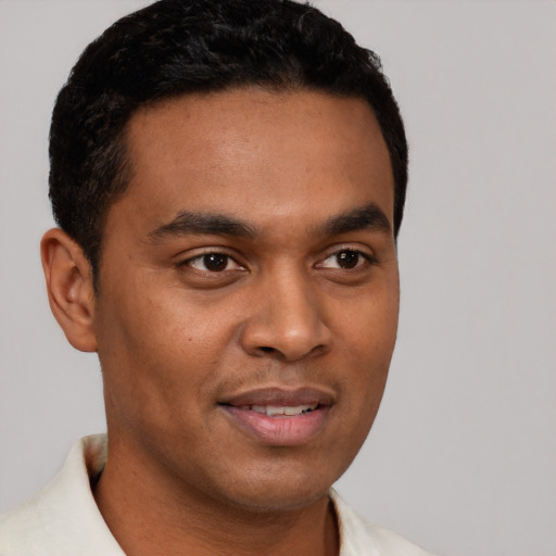 Joyful latino young-adult male with short  brown hair and brown eyes