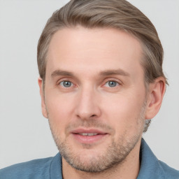 Joyful white adult male with short  brown hair and blue eyes