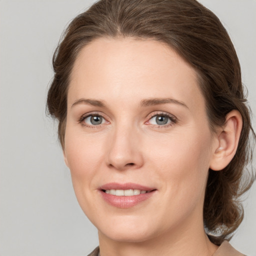 Joyful white young-adult female with medium  brown hair and grey eyes