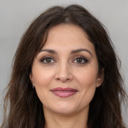 Joyful white adult female with long  brown hair and brown eyes