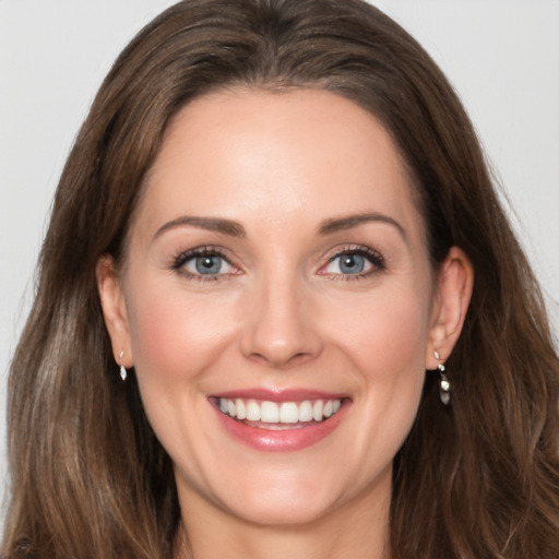 Joyful white young-adult female with long  brown hair and grey eyes