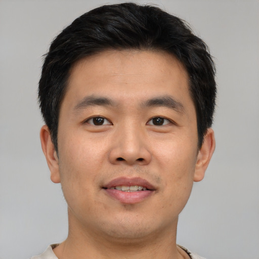 Joyful asian young-adult male with short  brown hair and brown eyes