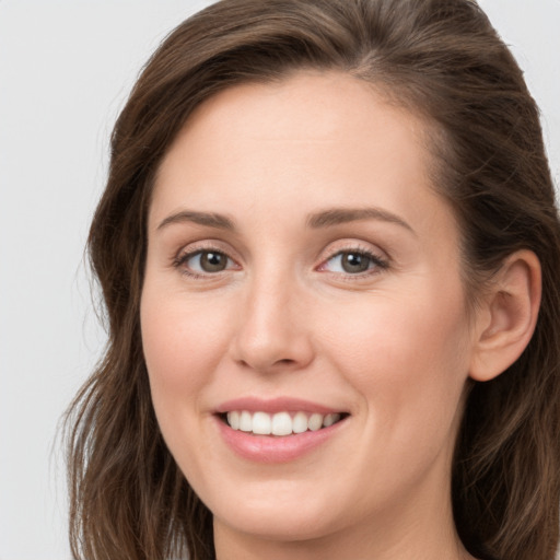 Joyful white young-adult female with long  brown hair and grey eyes