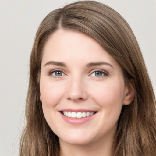 Joyful white young-adult female with long  brown hair and grey eyes