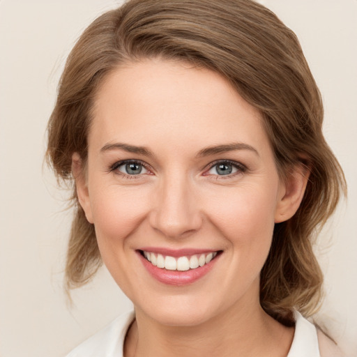 Joyful white young-adult female with medium  brown hair and green eyes