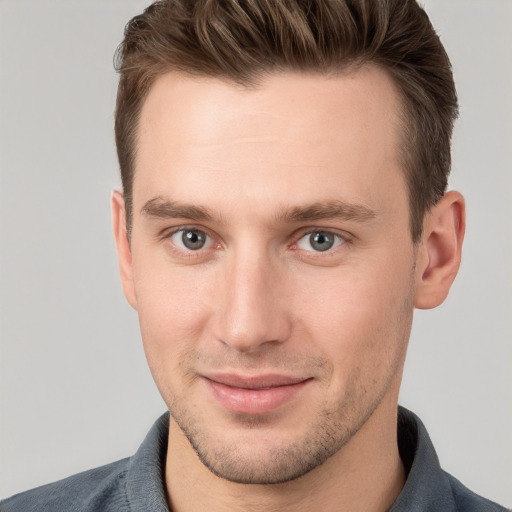 Joyful white young-adult male with short  brown hair and grey eyes