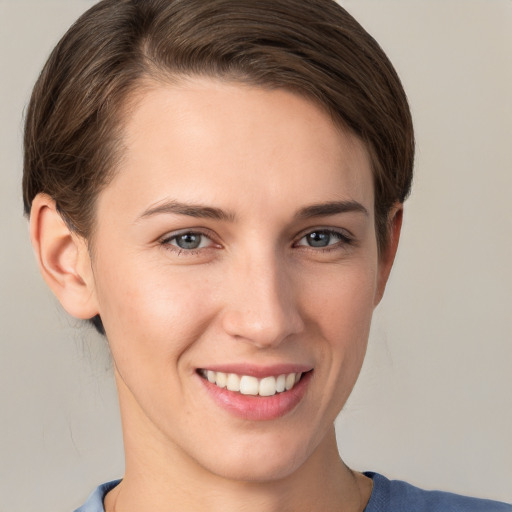 Joyful white young-adult female with short  brown hair and grey eyes