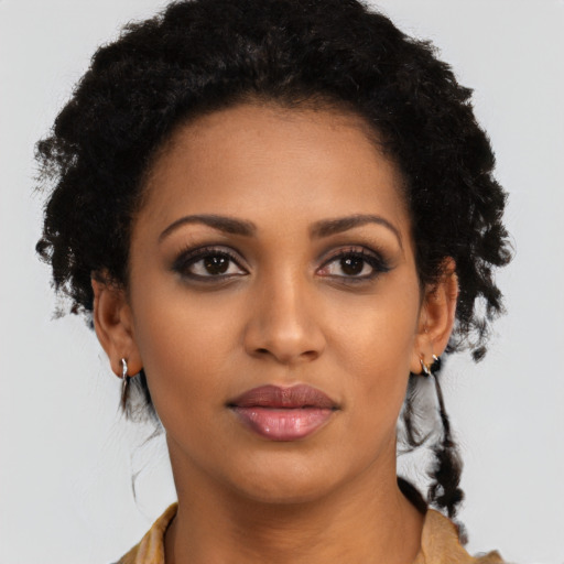 Joyful black young-adult female with long  brown hair and brown eyes