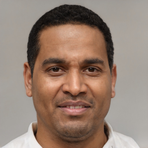 Joyful latino adult male with short  brown hair and brown eyes