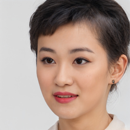 Joyful asian young-adult female with short  brown hair and brown eyes