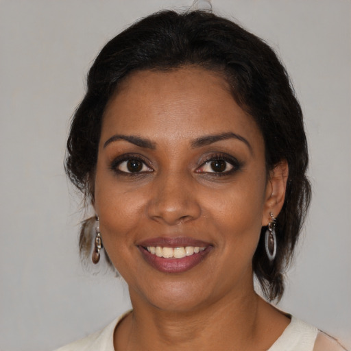 Joyful black young-adult female with medium  brown hair and brown eyes