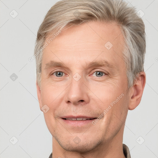 Joyful white adult male with short  brown hair and grey eyes