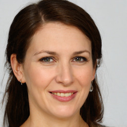 Joyful white adult female with medium  brown hair and grey eyes