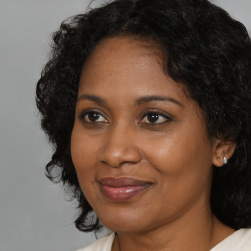 Joyful black adult female with medium  brown hair and brown eyes