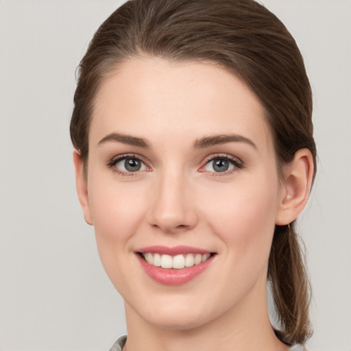 Joyful white young-adult female with medium  brown hair and grey eyes