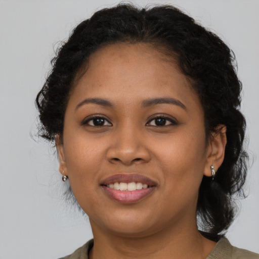 Joyful black young-adult female with long  black hair and brown eyes