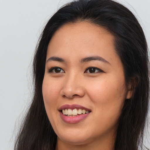 Joyful asian young-adult female with long  brown hair and brown eyes