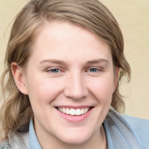 Joyful white young-adult female with medium  brown hair and blue eyes