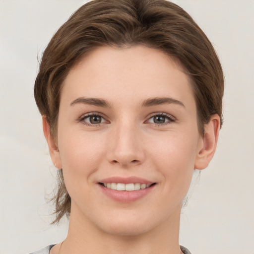 Joyful white young-adult female with short  brown hair and grey eyes