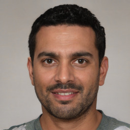 Joyful white young-adult male with short  black hair and brown eyes